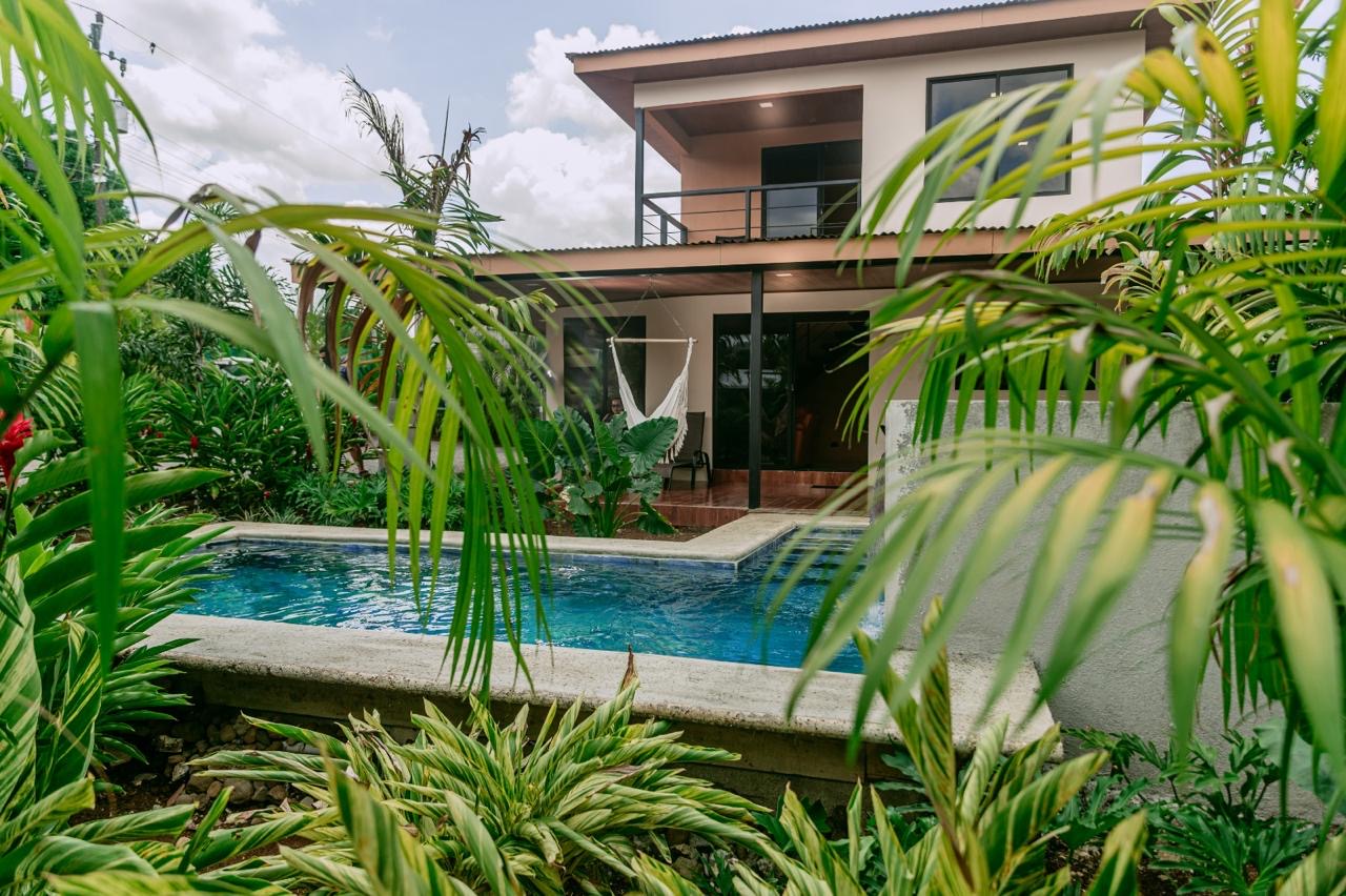Front view of two-story home surrounded by tropical garden in Chachagua, Costa Rica