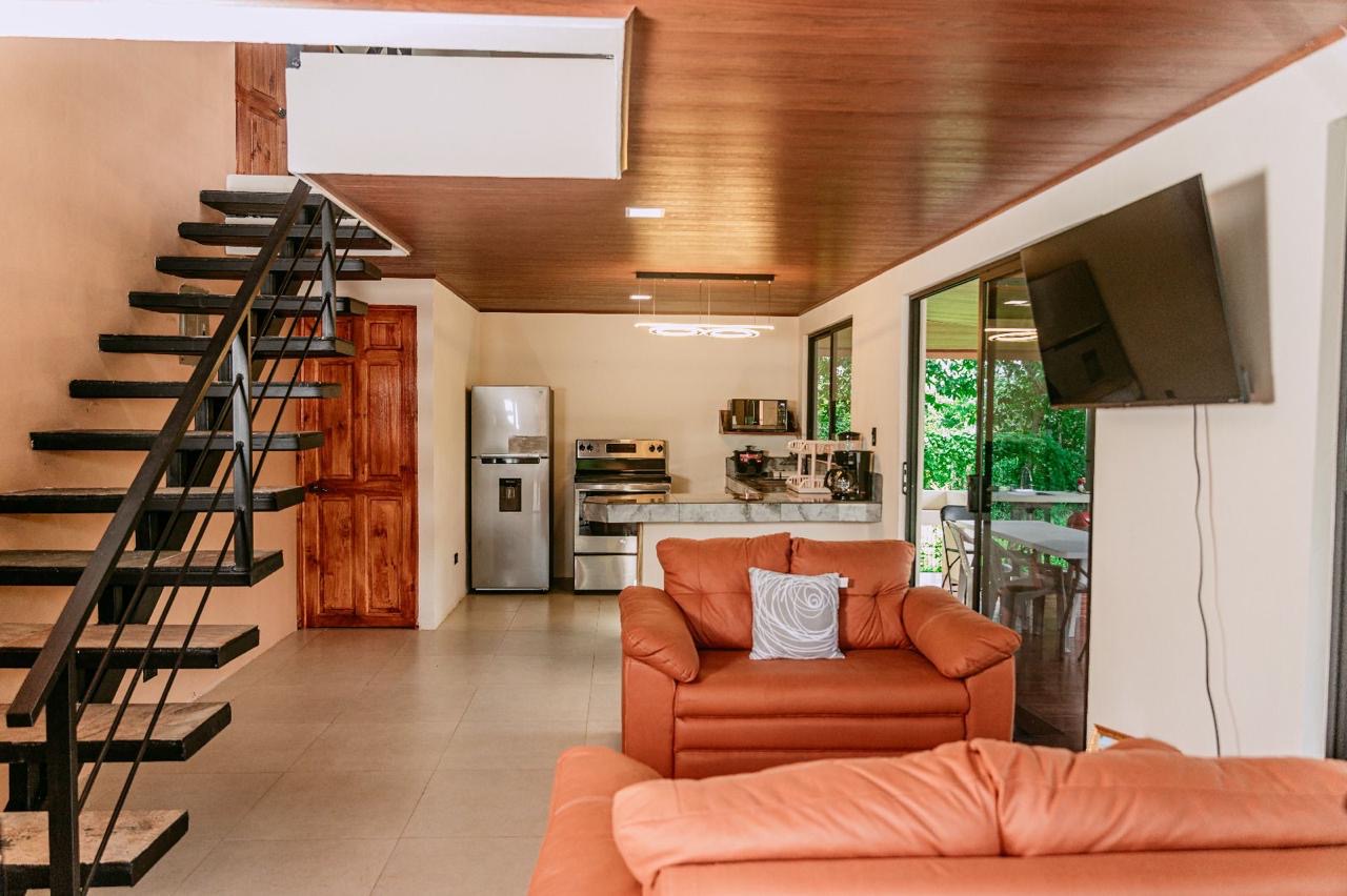 Open living room and kitchen with staircase in Chachagua, Costa Rica home