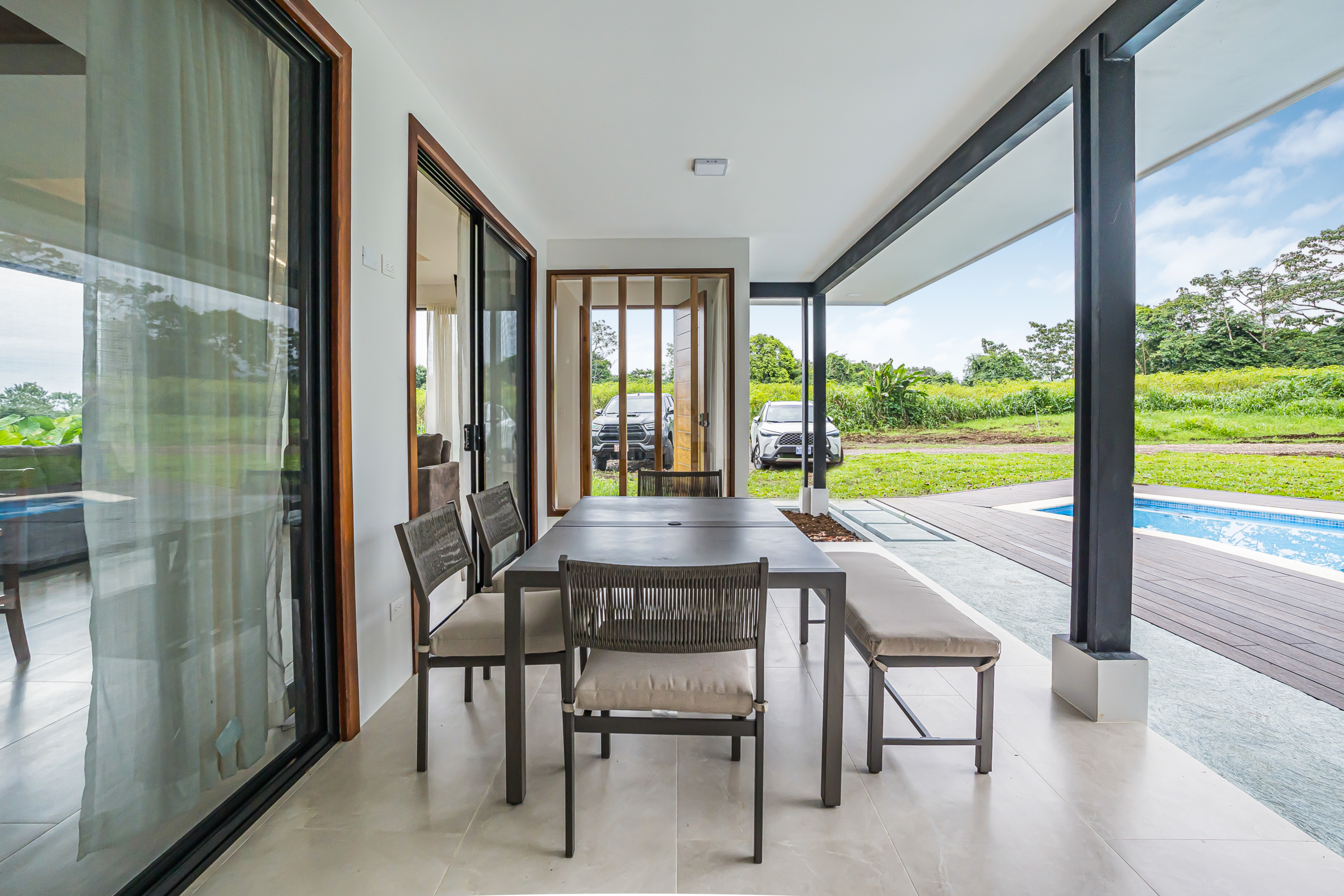 Covered outdoor dining area with pool and kitchen view, home near downtown La Fortuna, Costa Rica