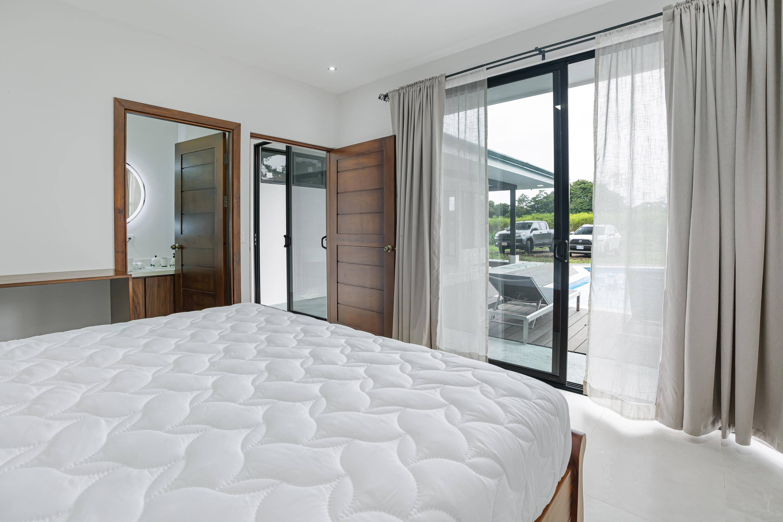 Master bedroom with direct pool access and en-suite bathroom in La Fortuna, Costa Rica home