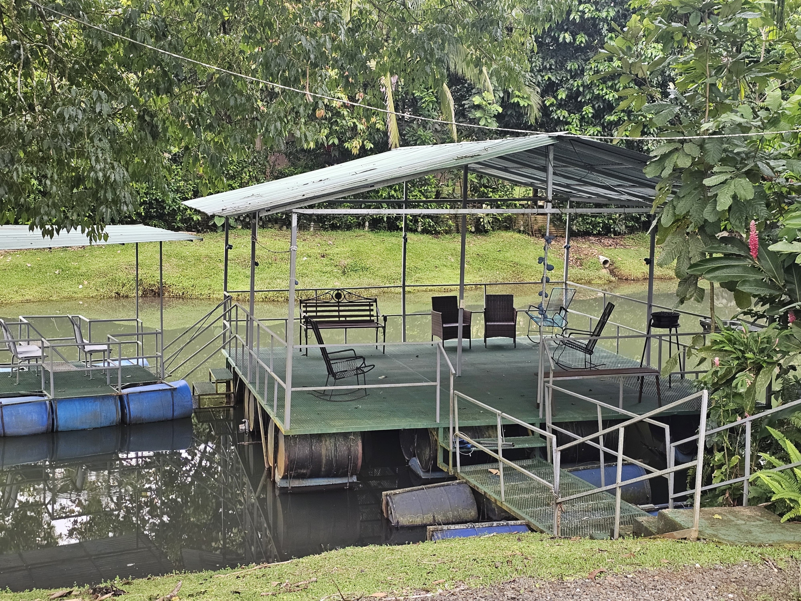 Covered floating deck with seating over the pond at the multi-home property near La Fortuna, Costa Rica